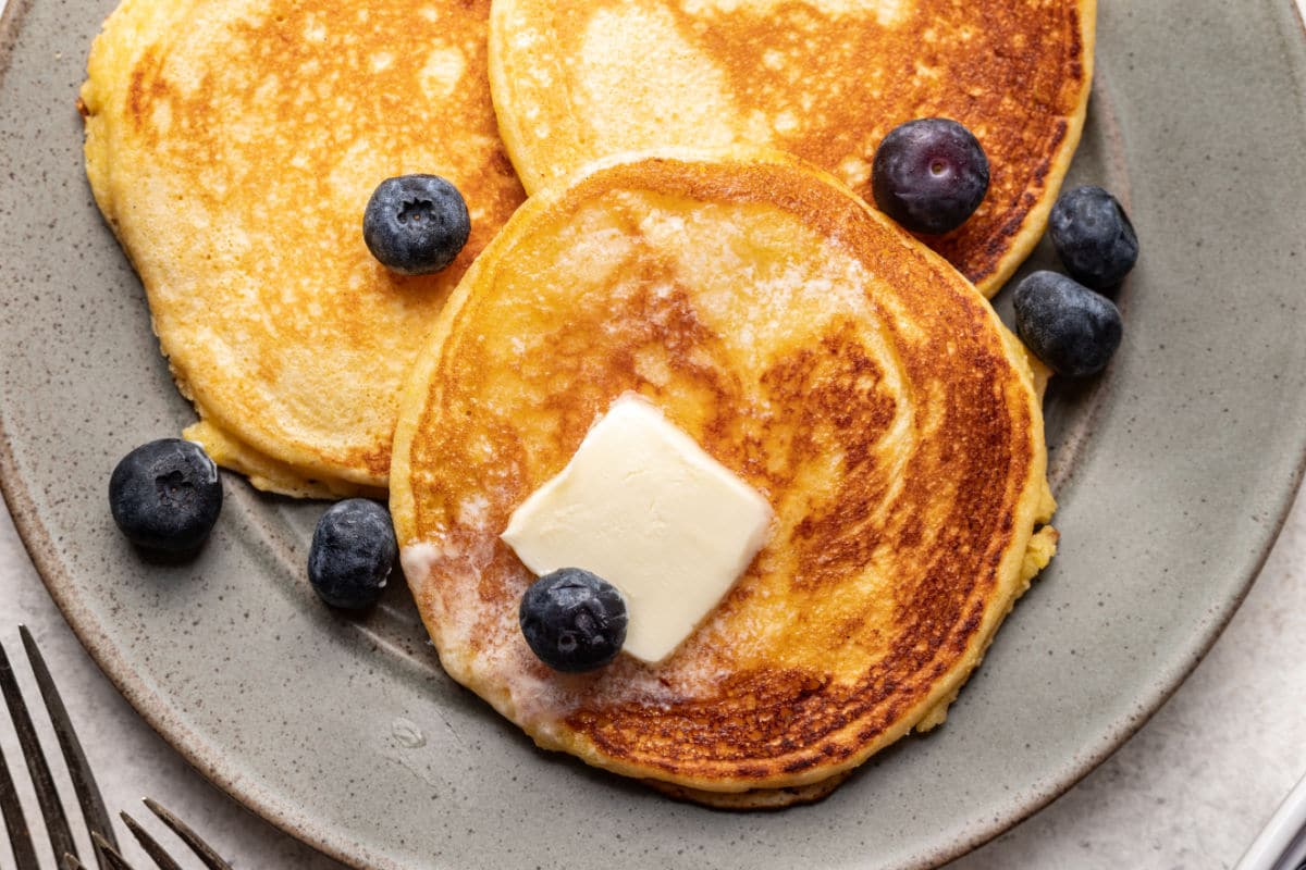 Un gâteau de maïs garni d'une noisette de beurre et de quelques myrtilles fraîches.