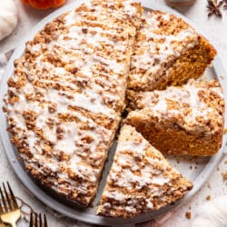 A partially sliced pumpkin coffee cake on a platter.