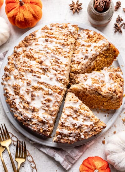 A partially sliced pumpkin coffee cake on a platter.