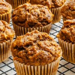 Pumpkin banana muffins in a row on a wire cooling rack.
