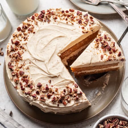 A frosted sweet potato cake with a on a cake server.