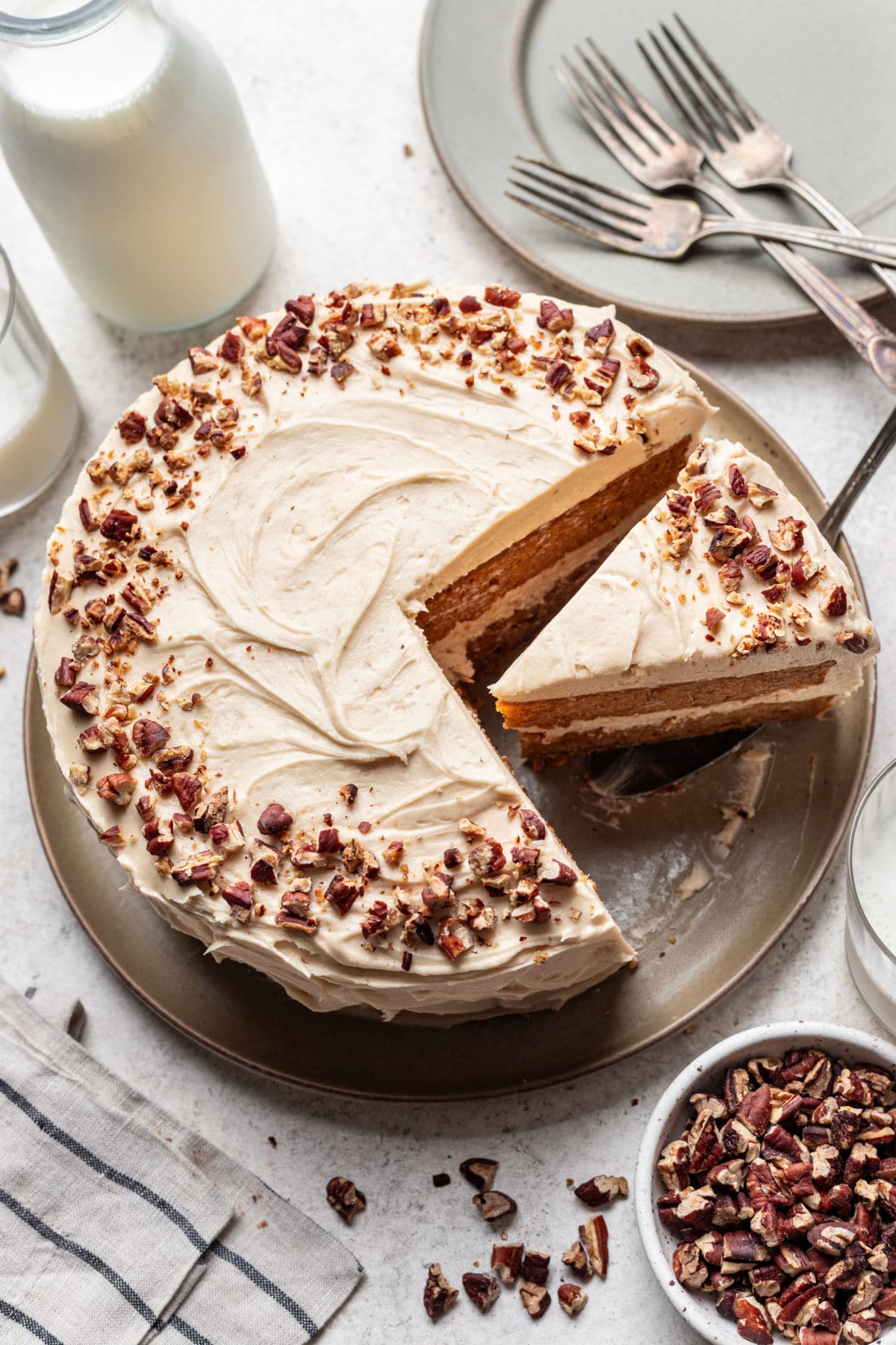 A frosted sweet potato cake with a on a cake server.