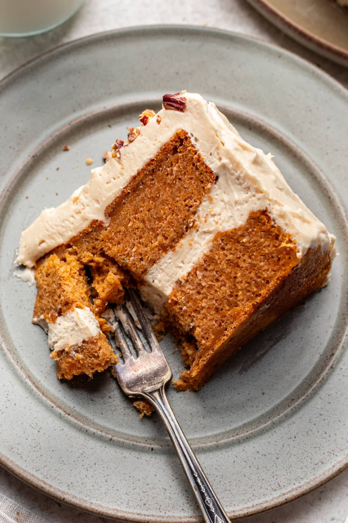 A fork taking a bite of a slice of sweet potato cake. 