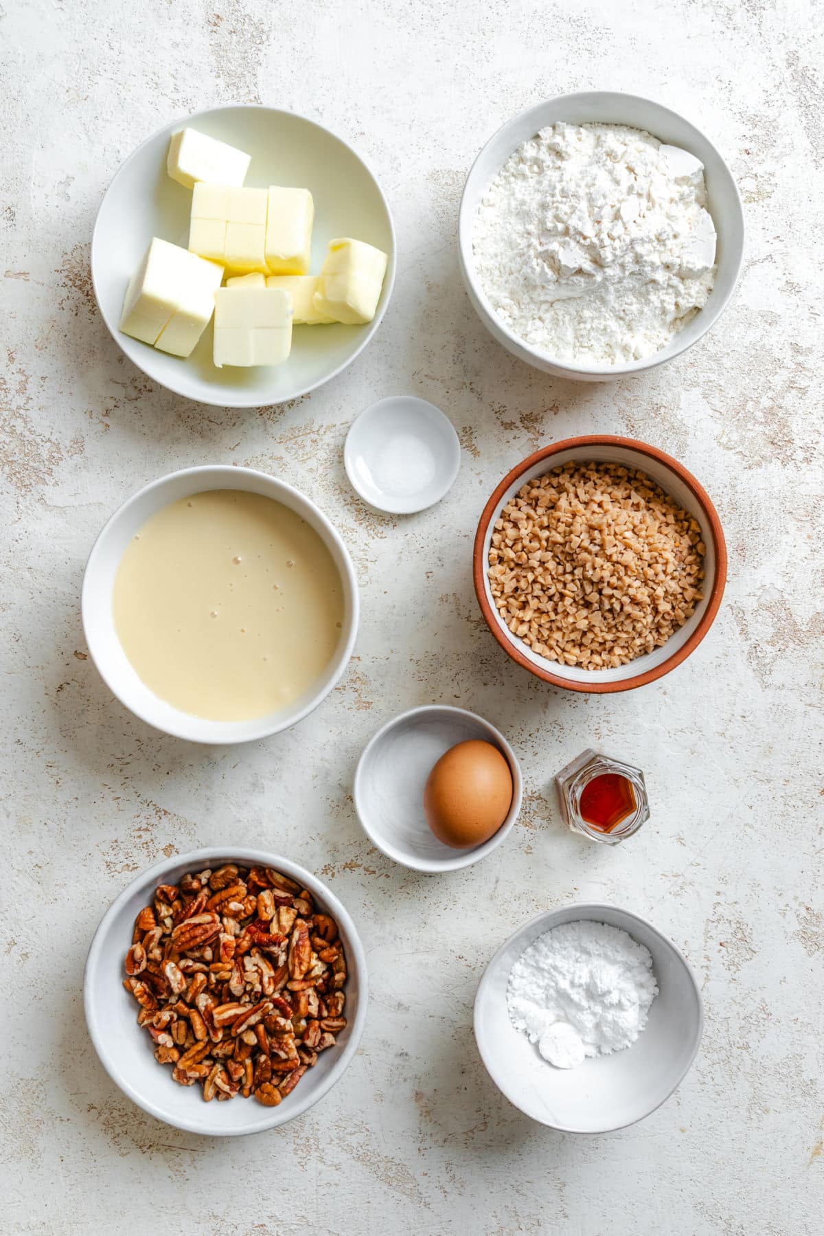 Ingredients for toffee pecan pie bars in dishes. 