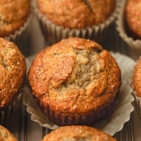 Rows of maple banana muffins on a piece of brown parchment paper.