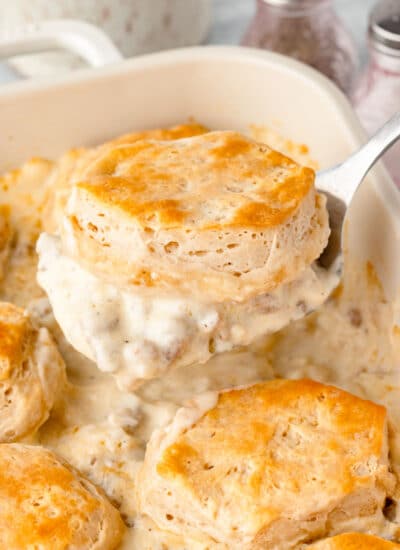 A spatula holding up a scoop of biscuits and gravy casserole.