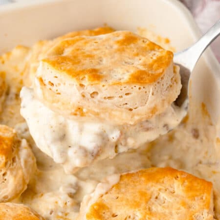 A spatula holding up a scoop of biscuits and gravy casserole.