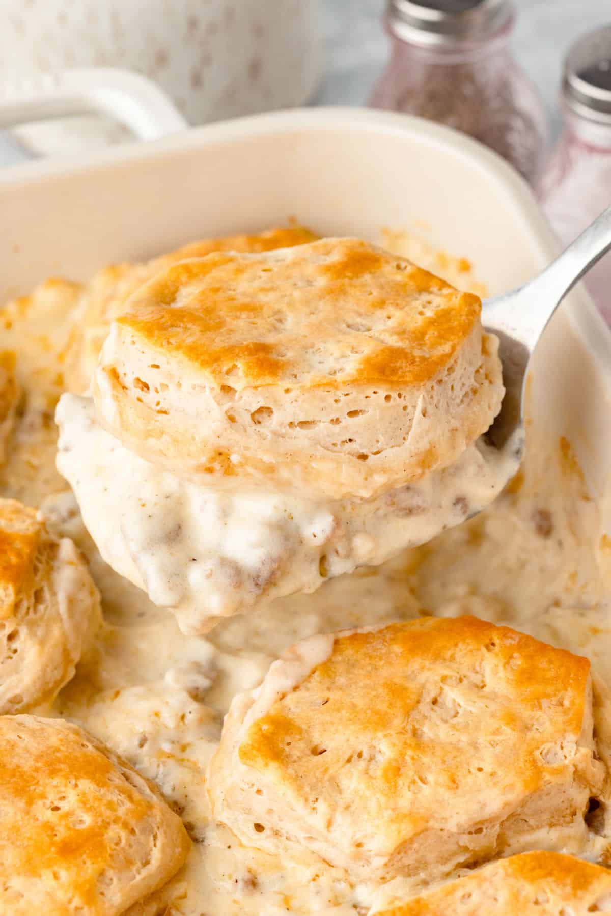 A spatula holding up a scoop of biscuits and gravy casserole.