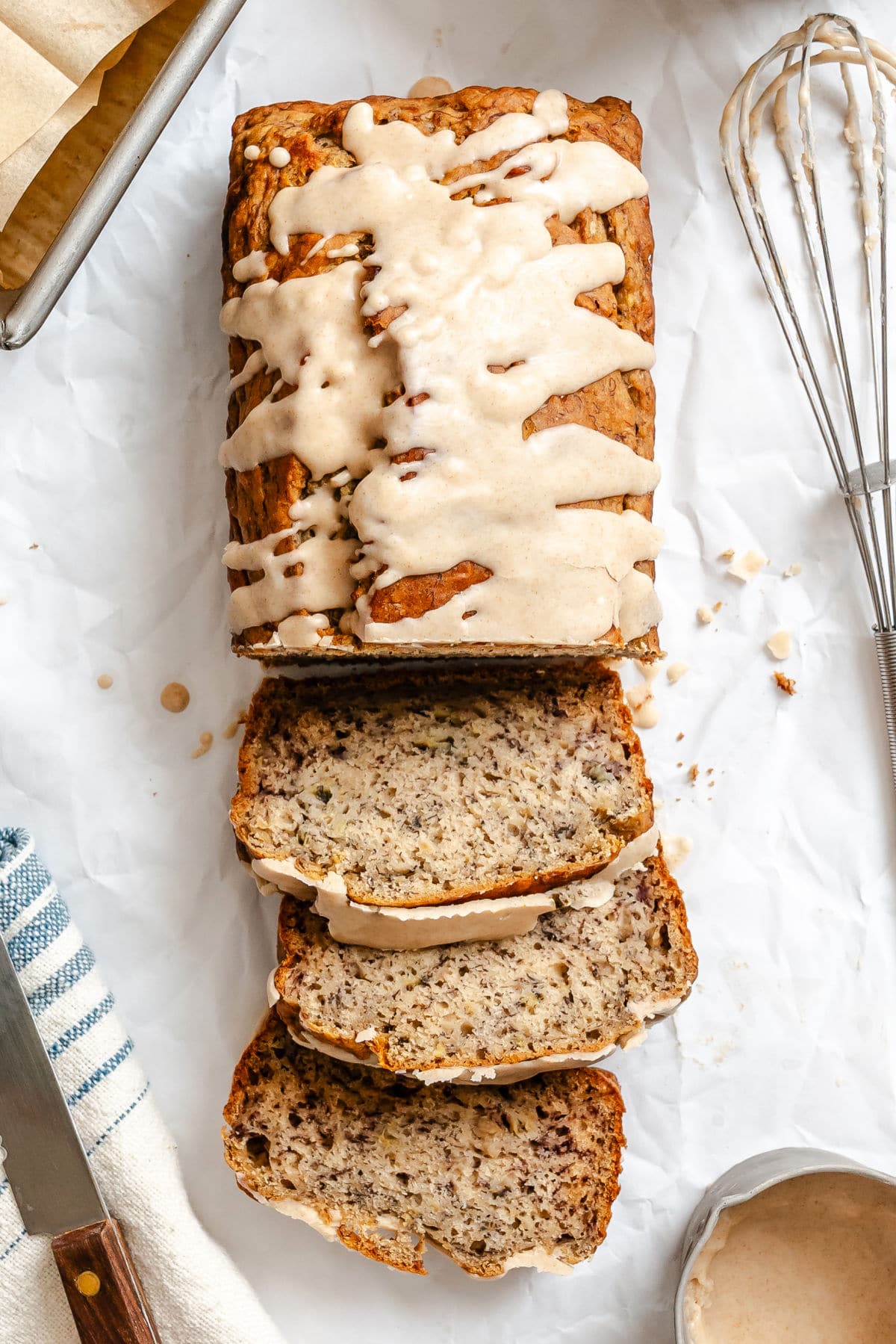 A loaf of brown butter glazed banana bread with three slices cut from the loaf.