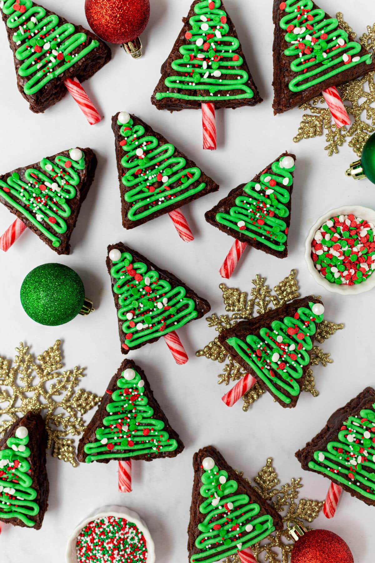 Christmas tree brownies with ornaments nearby.