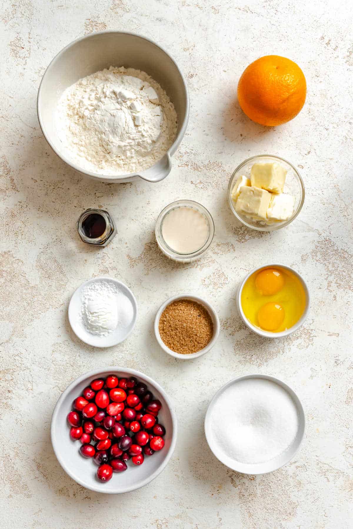 Ingredients for cranberry orange muffins in dishes. 