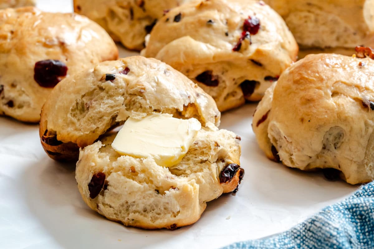 A cranberry wild rice roll cut in half with a pat of butter in the center. 