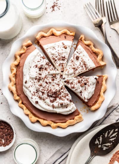 A French silk pie in a pie pan with three slices cut.