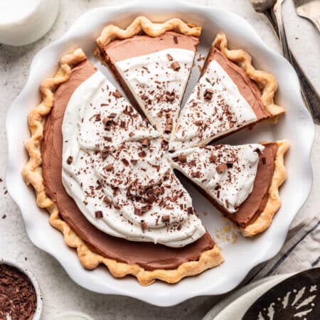 A French silk pie in a pie pan with three slices cut.