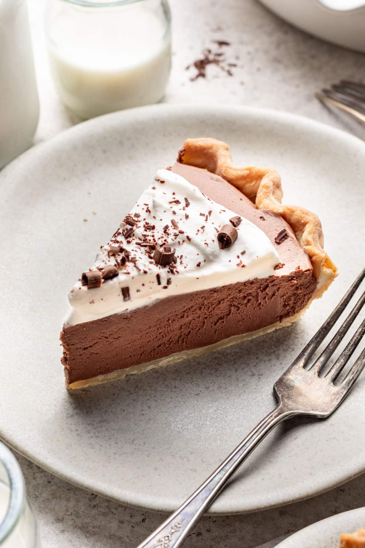 A slice of homemade French silk pie on a plate with a fork next to it. 