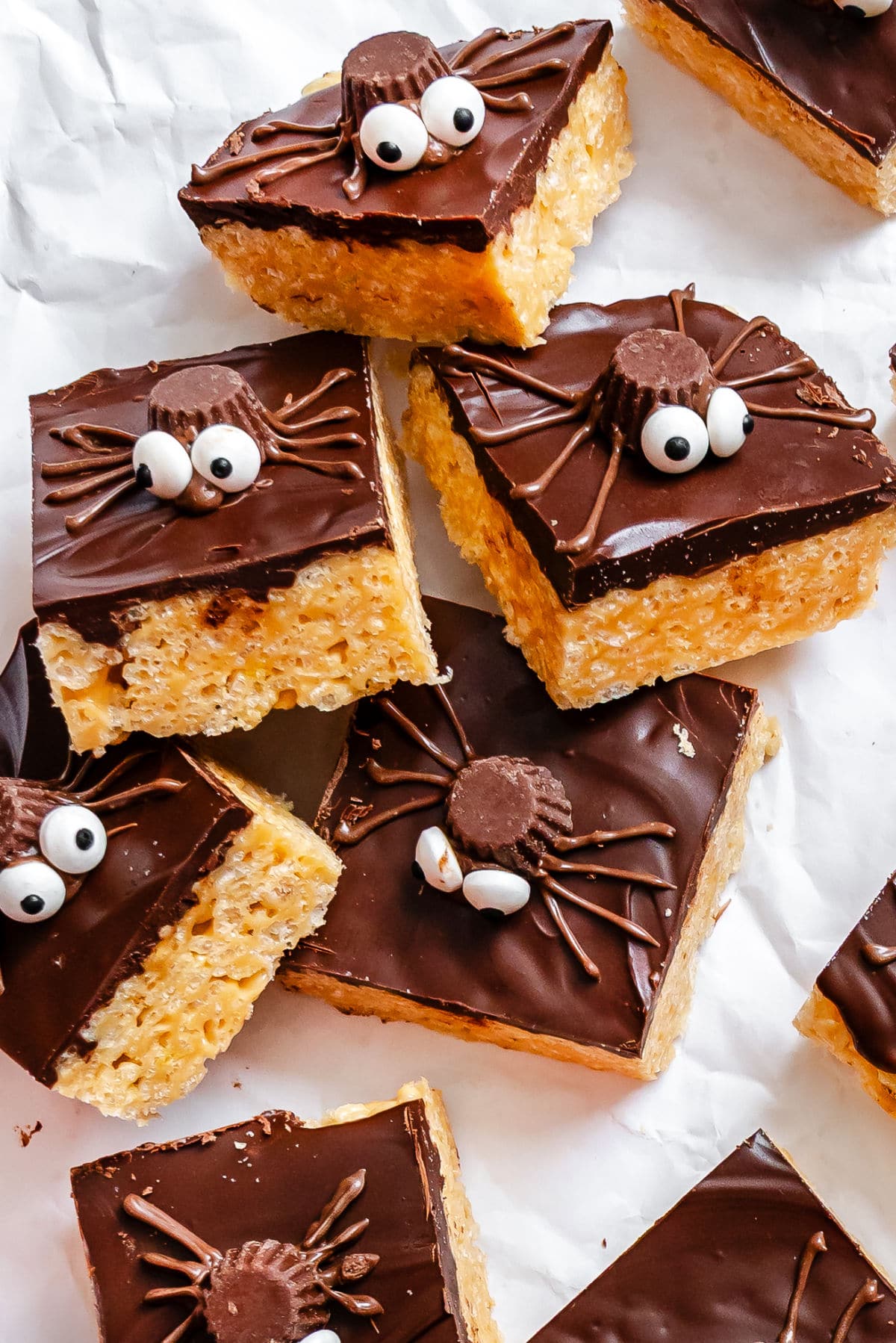 Stacked Halloween Rice Krispies treats on white parchment paper.