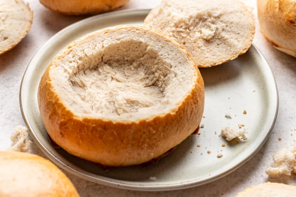 A hollowed out bread bowl on a plate.