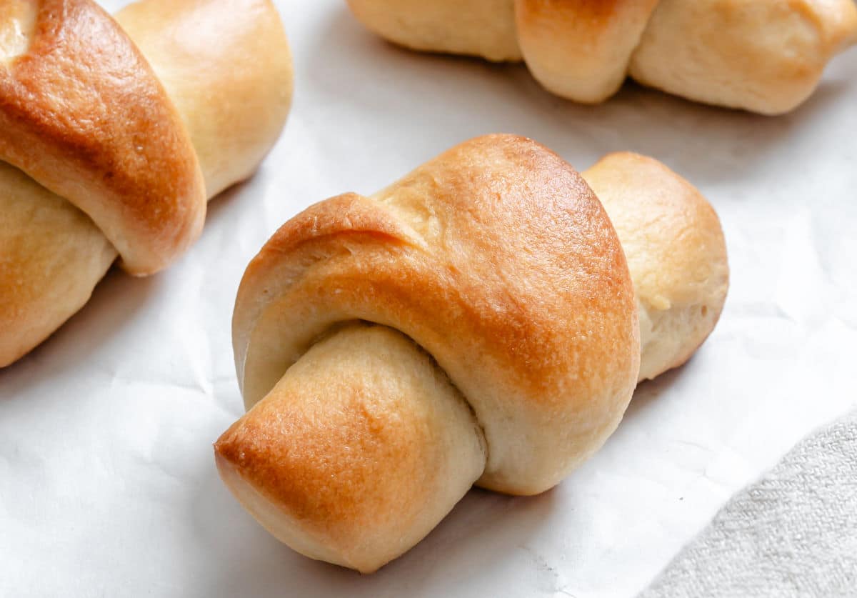 Baked crescent rolls on a piece of white parchment paper. 