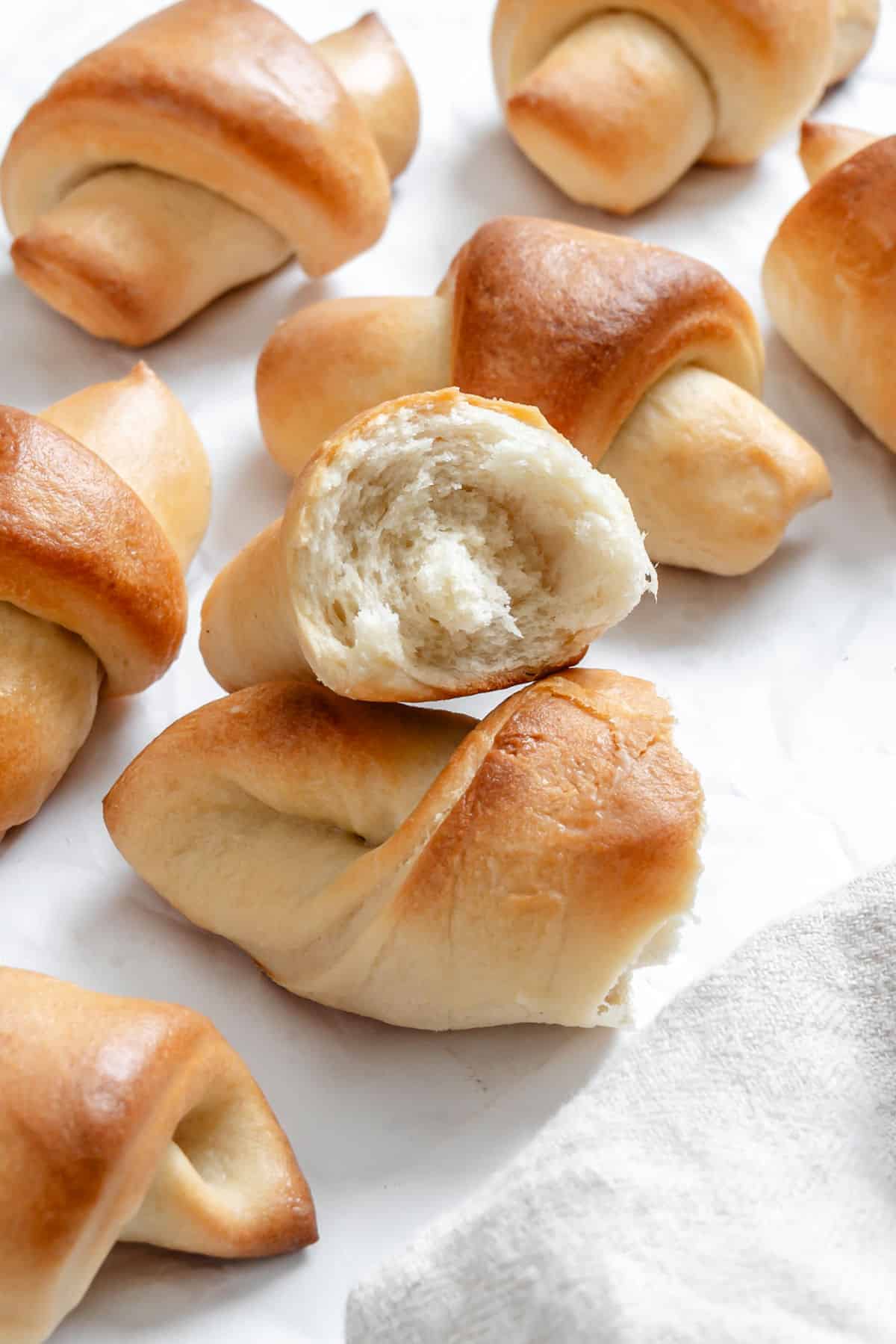 A crescent roll broken in half on top of another roll. 