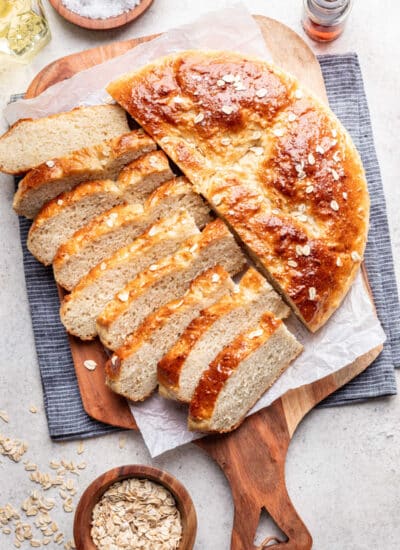 Half of a loaf of maple oat skillet bread sliced next to the rest of the loaf.