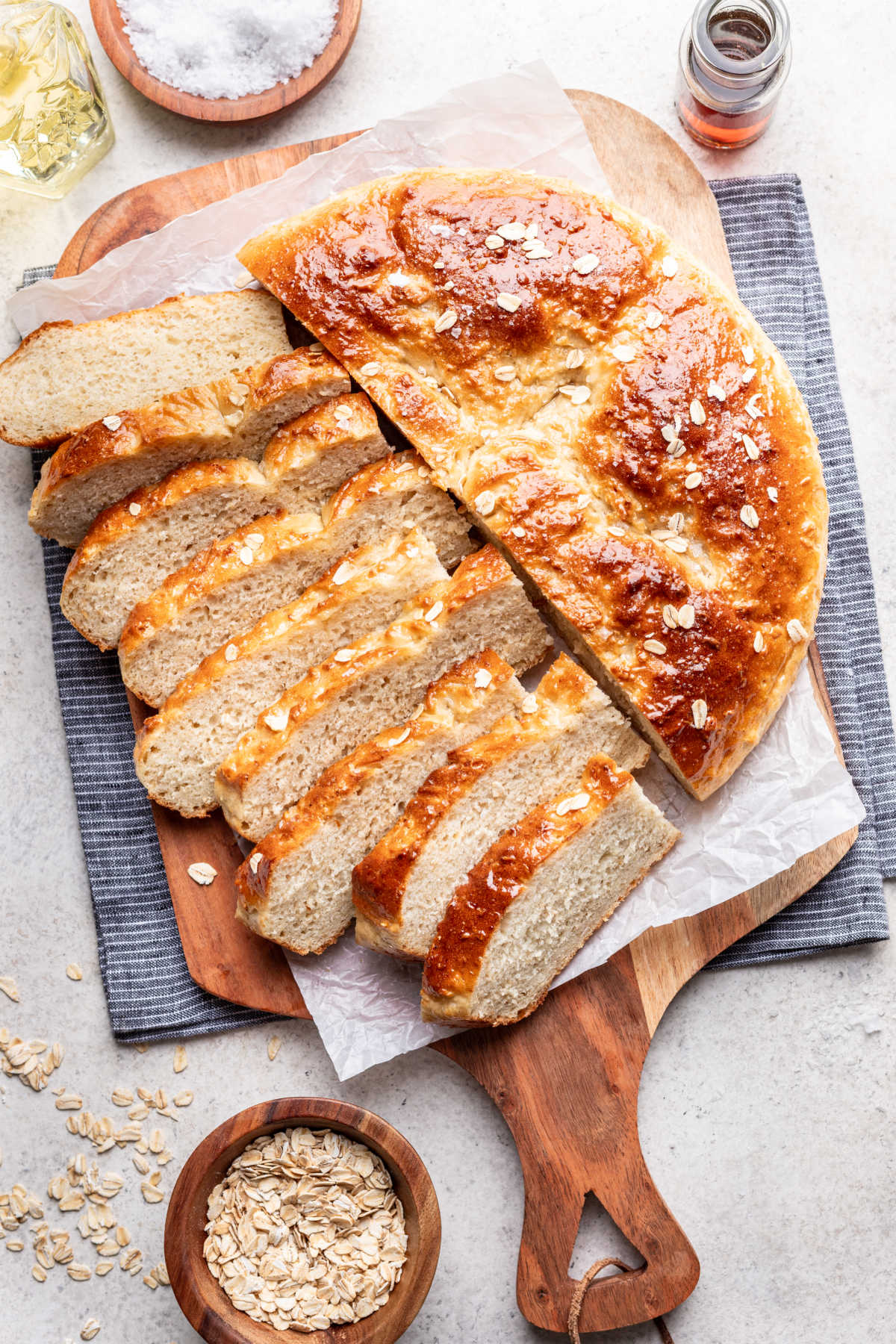 Half of a loaf of maple oat skillet bread sliced next to the rest of the loaf.