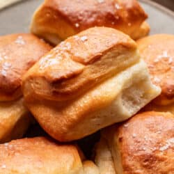 A parker house roll on top of other rolls.