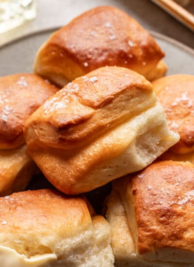 A parker house roll on top of other rolls.