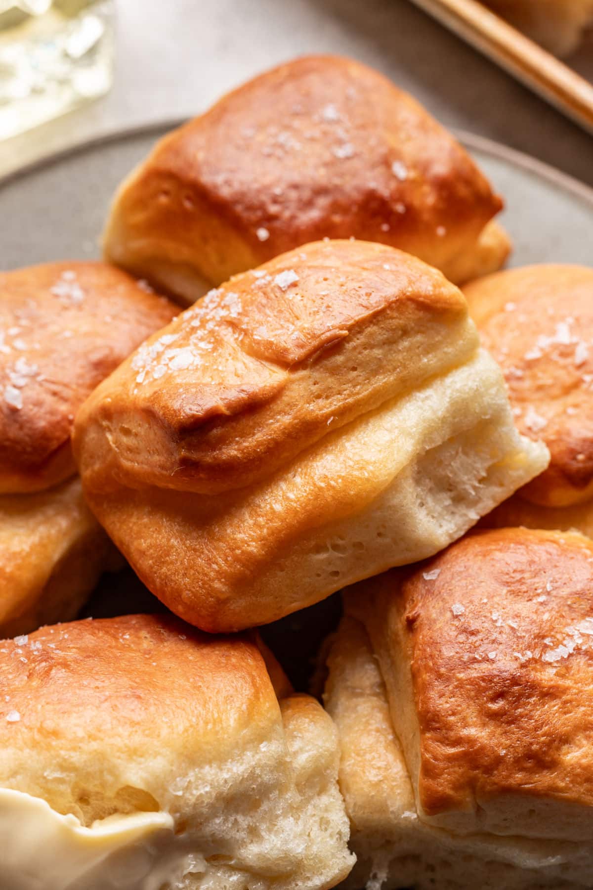 A parker house roll on top of other rolls.
