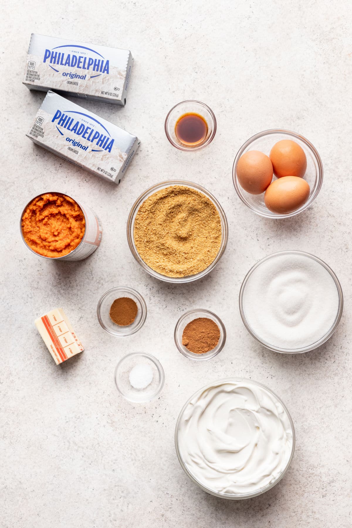 Ingredients for pumpkin cheesecake bars in dishes. 