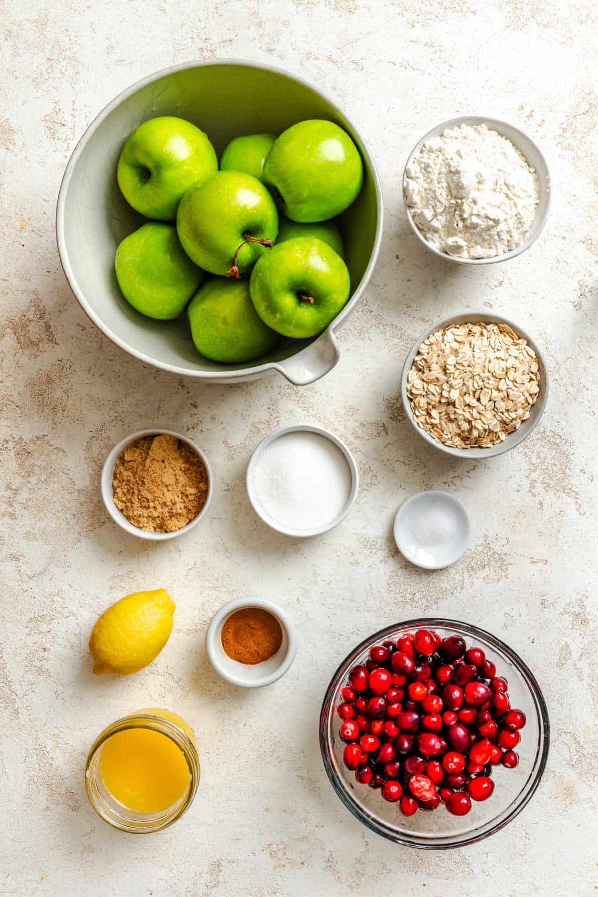 Ingredients for slow cooker cranberry apple crisp in dishes. 