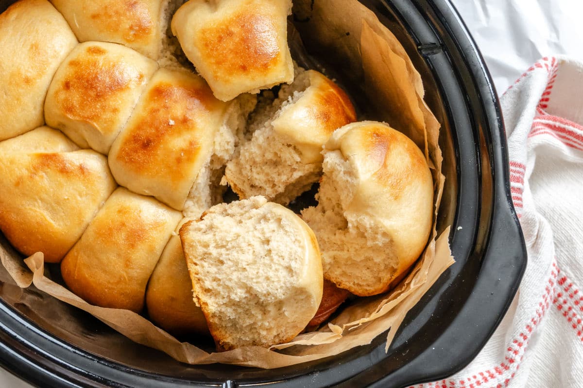 Rolls on top of each other in a slow cooker insert. 