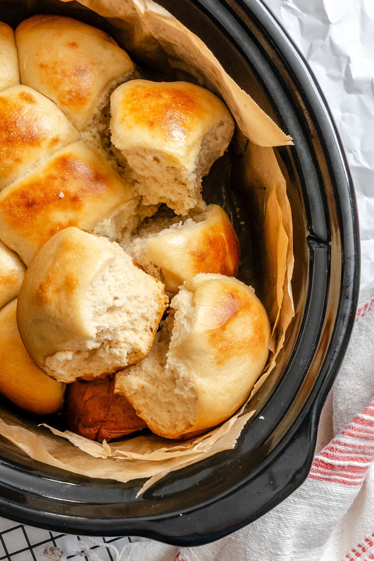 Slow cooker dinner rolls overlapping in a a crock pot. 