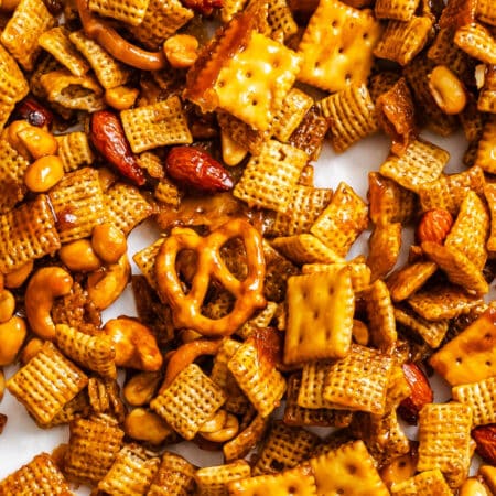 Toffee Chex mix spread out on a piece of white parchment paper.