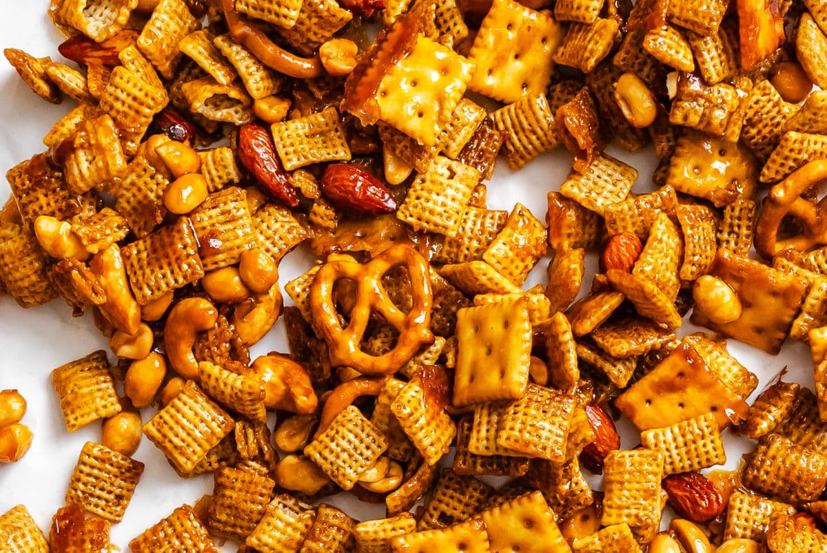 Toffee Chex mix spread out on a piece of white parchment paper.