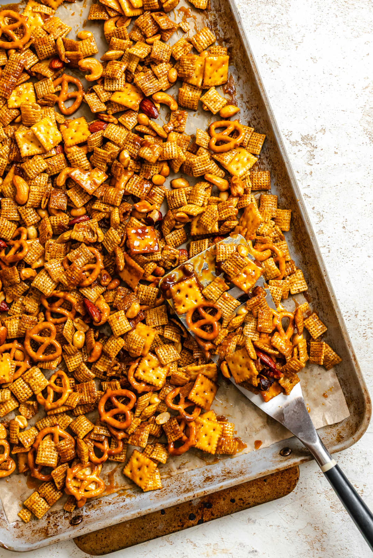 A tray of toffee Chex mix on a trivet. 