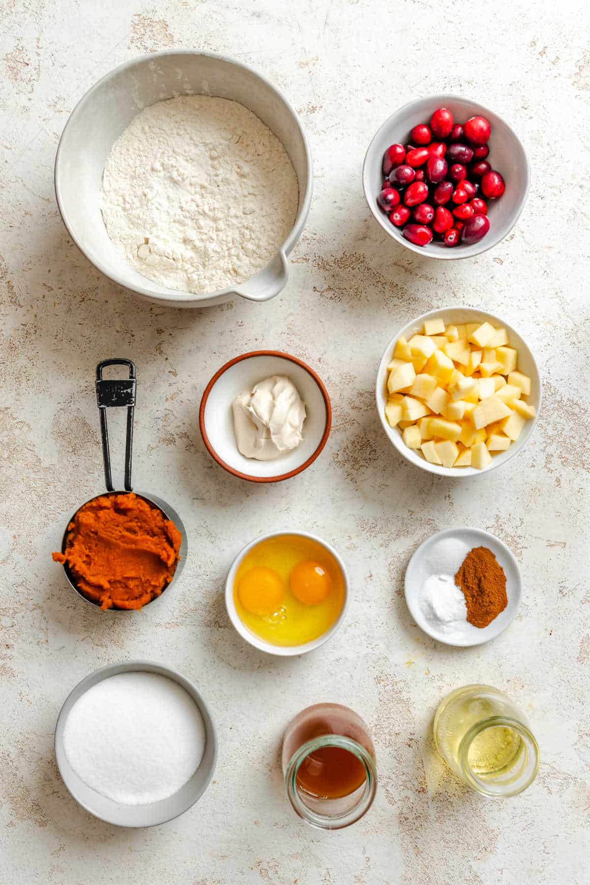 Ingredients for pumpkin cranberry muffins in dishes. 