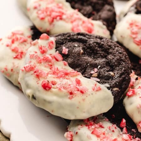 A platter of overlapping chocolate candy cane cookies.
