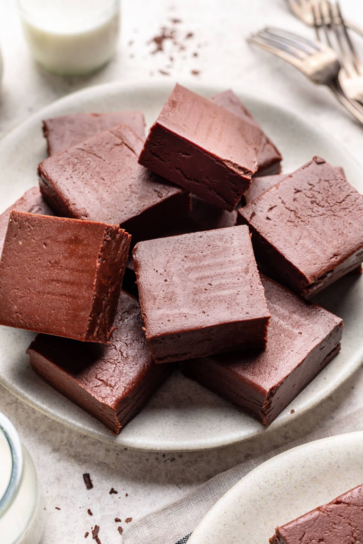 A plate of chocolate fudge with pieces overlapping.