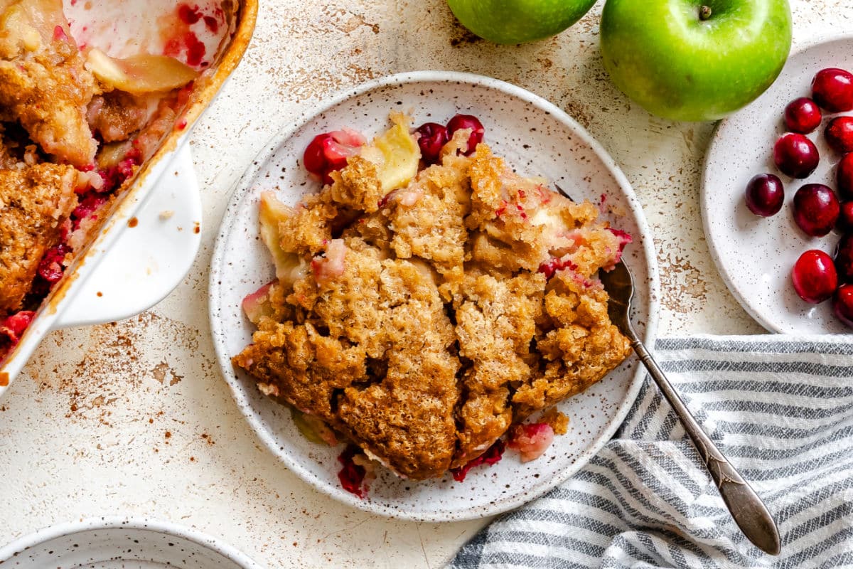 A plate of cranberry apple cobbler with a fork in it.