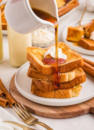 Syrup pouring onto a stack of eggnog French toast.