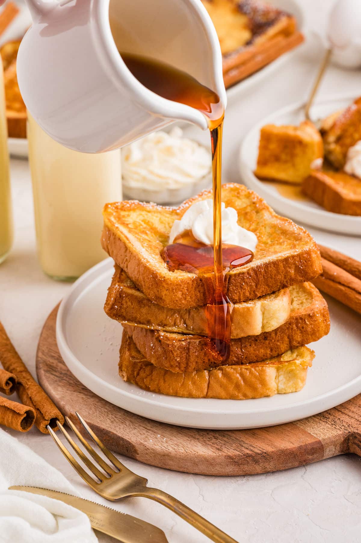 Syrup pouring onto a stack of eggnog French toast.