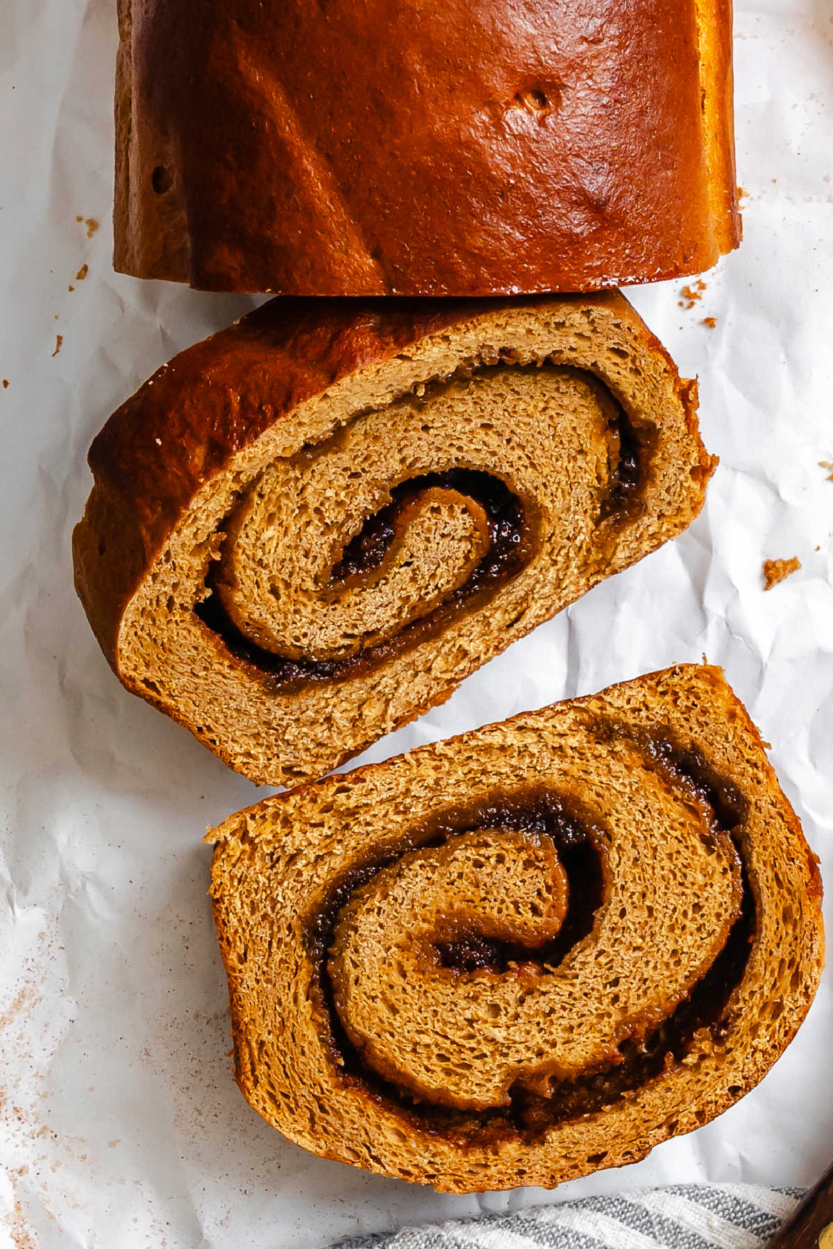 Two slices of gingerbread cinnamon swirl bread next to the loaf. 