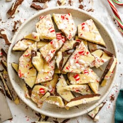 A plate of homemade peppermint bark next to candy canes.