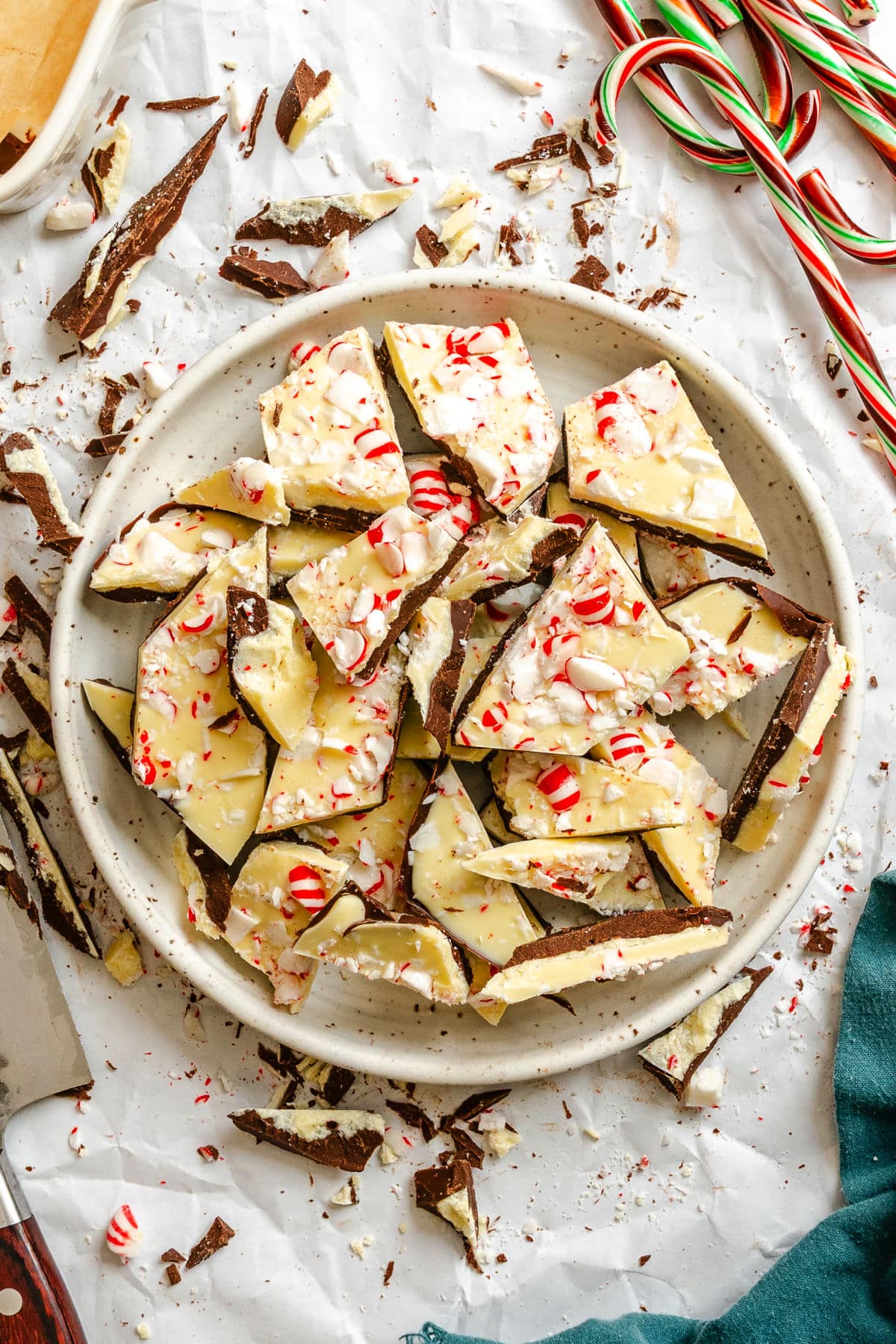 A plate of homemade peppermint bark next to candy canes.