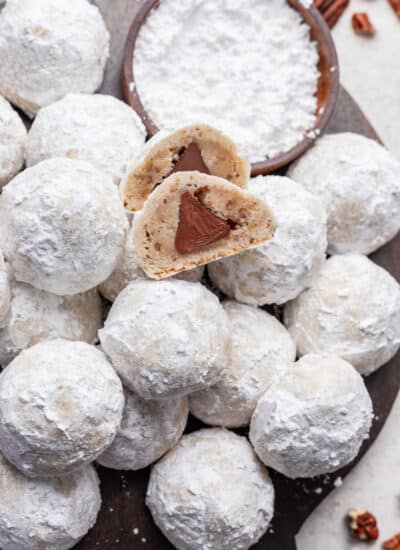 A snowball kiss cookie cut in half on more kiss cookies.