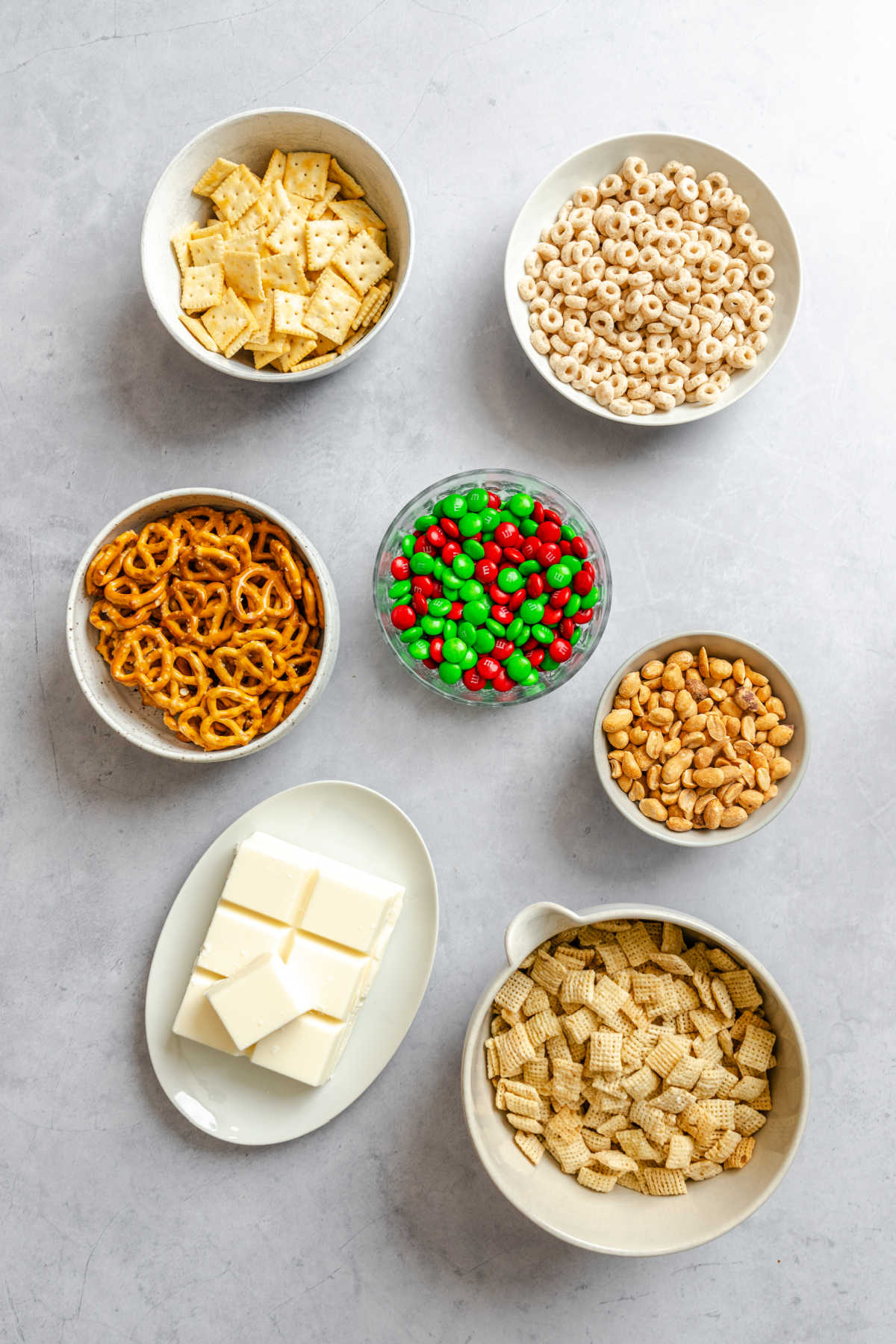 Ingredients for Christmas Chex mix in dishes. 