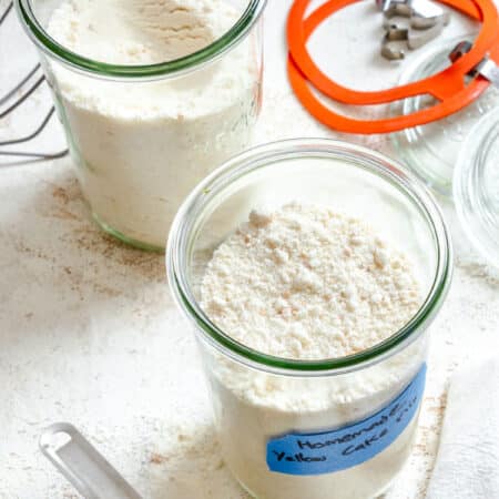 Two open glass jars filled with homemade yellow cake mix.