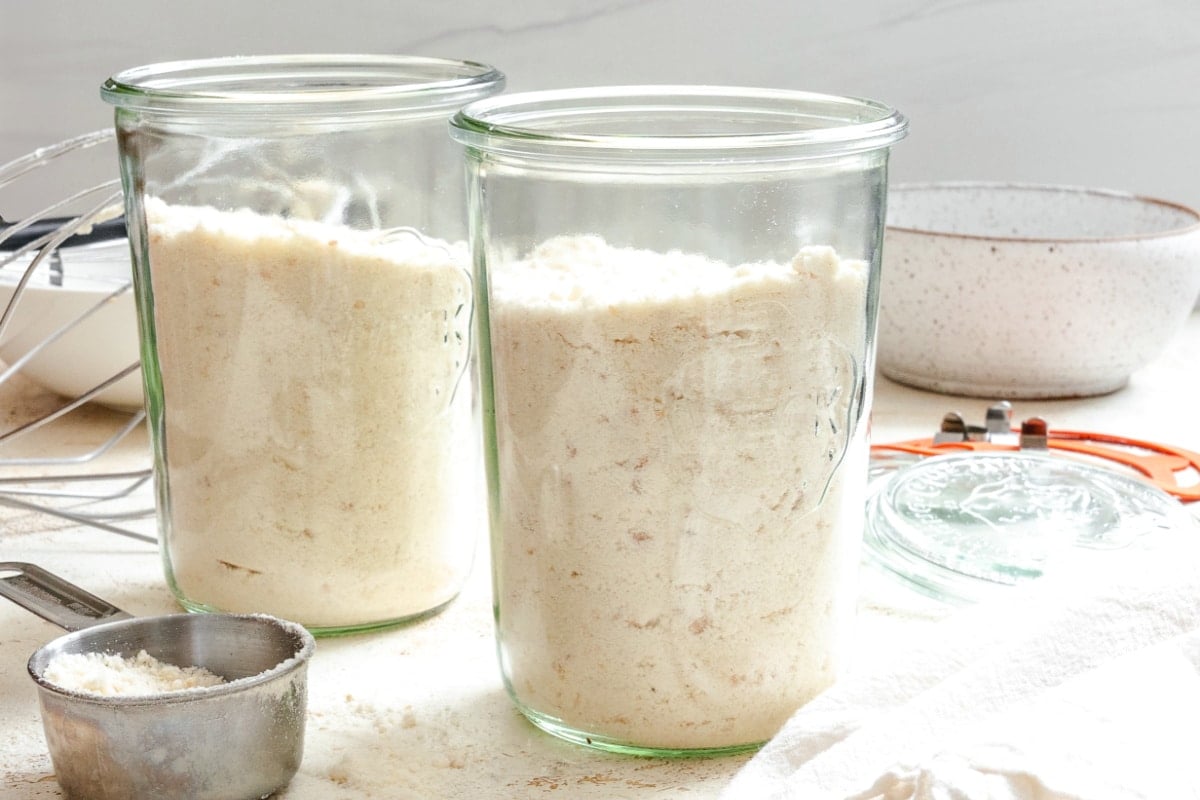 Homemade Yellow Cake Mix Two glass jars filled with homemade yellow cake mix next to a metal measuring cup.