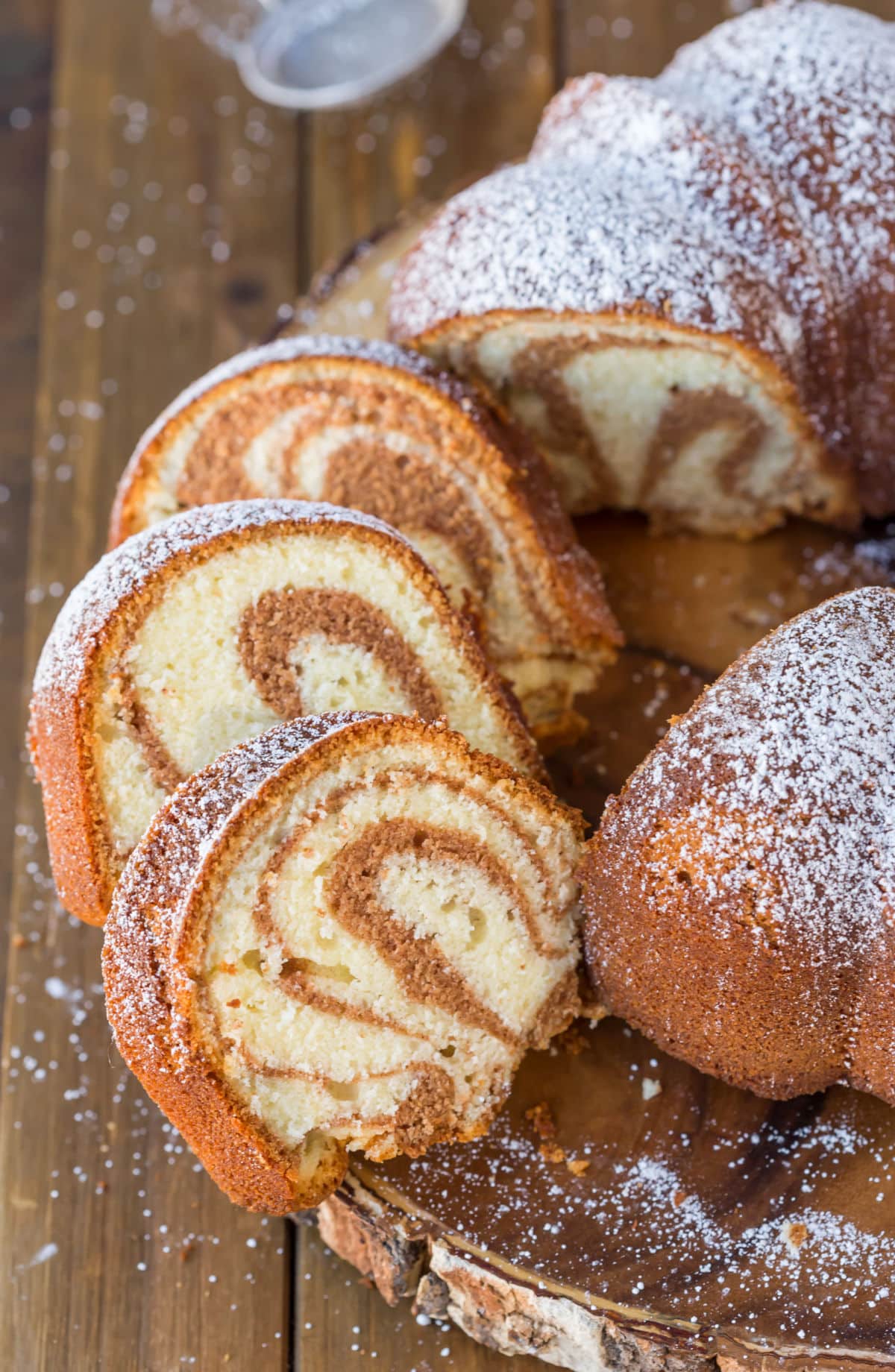 Pieces of cinnamon swirl bundt cake on a wooden plate.