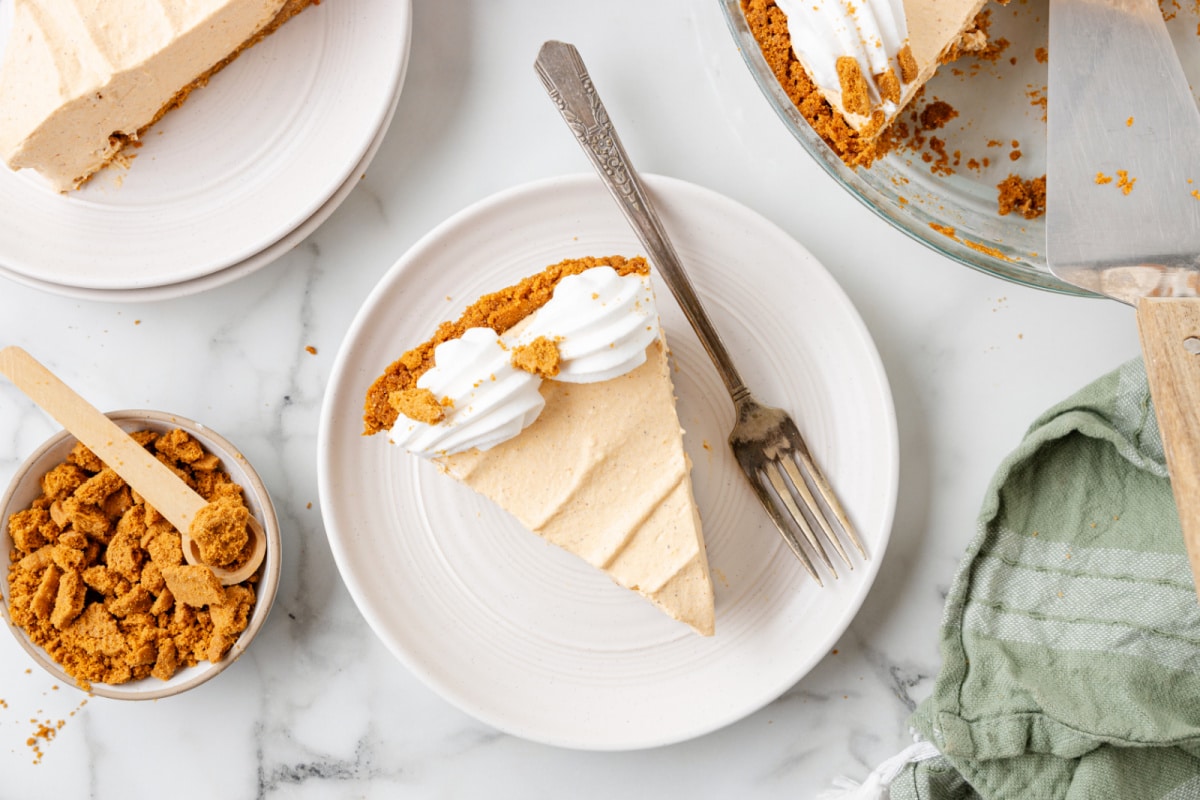 A slice of no bake pumpkin pie next to the pie in a pie pan.
